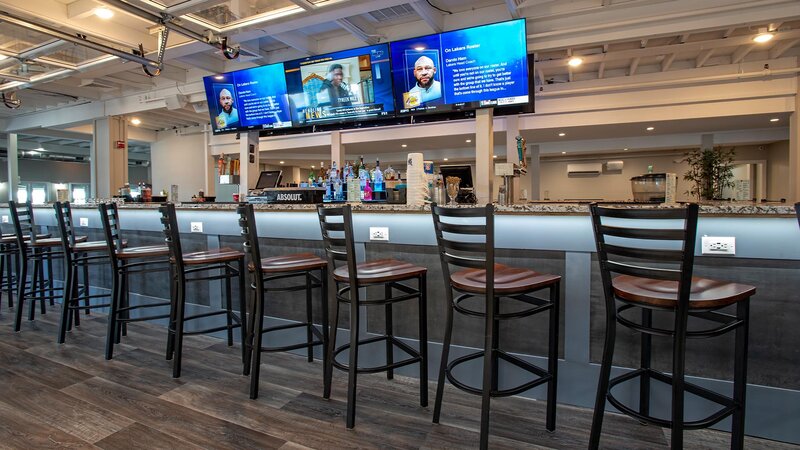 Bar with high back stools and view of flat screen tvs above bar